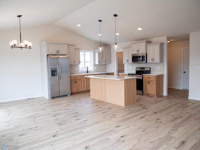 kitchen featuring stainless steel appliances, light wood finished floors, light countertops, a center island, and decorative backsplash