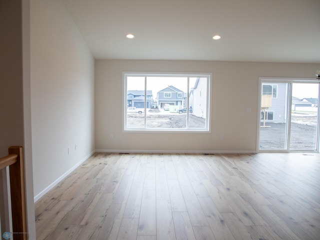 spare room featuring baseboards, light wood finished floors, recessed lighting, and plenty of natural light