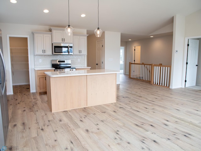 kitchen with light wood-type flooring, recessed lighting, backsplash, light countertops, and appliances with stainless steel finishes