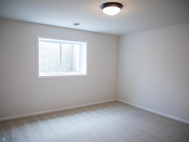 spare room featuring carpet flooring and baseboards