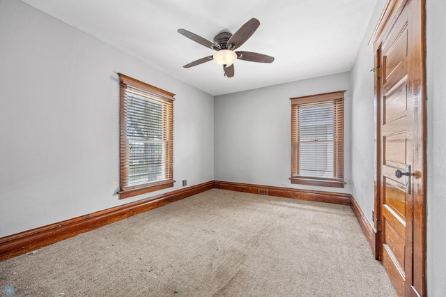 empty room with carpet, plenty of natural light, baseboards, and ceiling fan