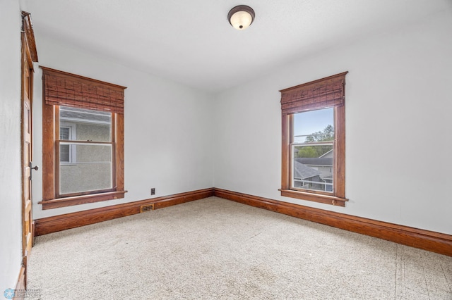 unfurnished room with baseboards