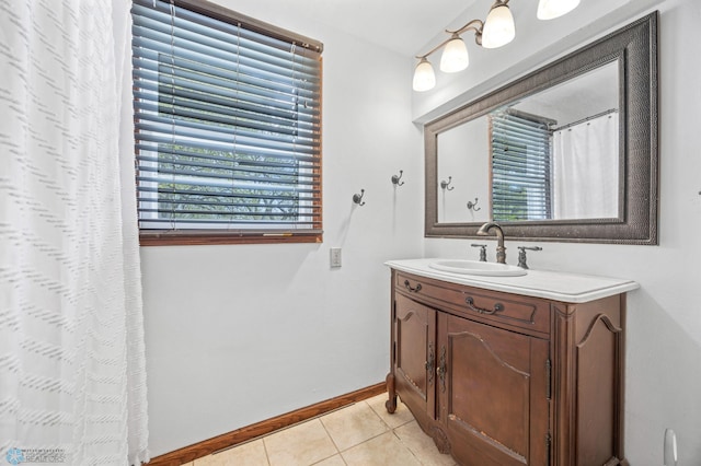 bathroom featuring plenty of natural light, tile patterned flooring, vanity, and baseboards