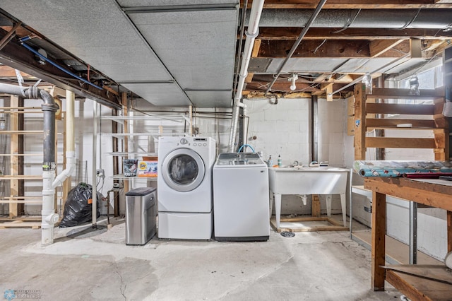 unfinished basement featuring independent washer and dryer, concrete block wall, and a workshop area