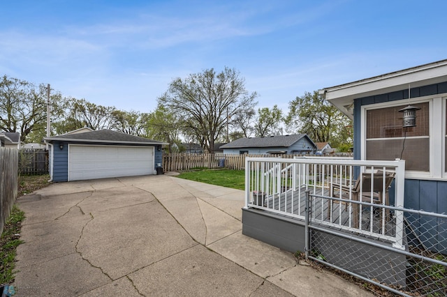 view of patio / terrace with an outdoor structure, fence, and a detached garage