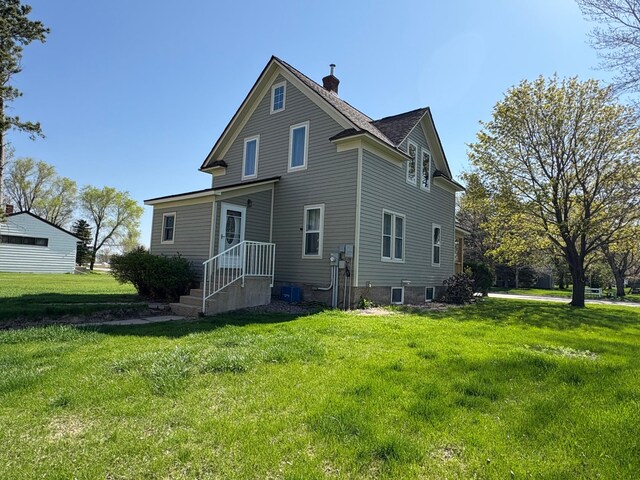 1105 13th St N, Benson, MN 56215 - back of house with a chimney and a lawn