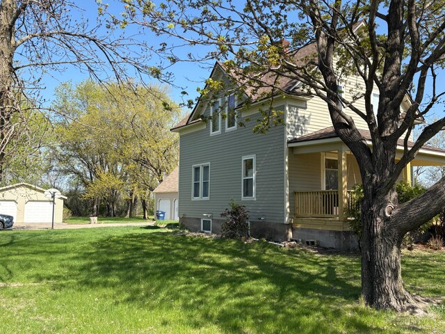 1105 13th St N, Benson, MN 56215 - view of property exterior featuring a garage, a lawn, covered porch, and a chimney