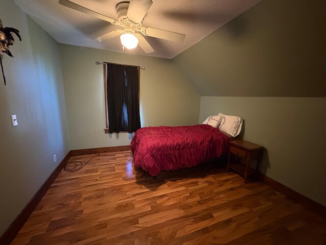 1105 13th St N, Benson, MN 56215 - bedroom with wood finished floors, a textured ceiling, baseboards, a ceiling fan, and vaulted ceiling