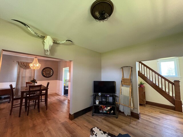 1105 13th St N, Benson, MN 56215 - living area featuring a chandelier, wood finished floors, stairway, baseboards, and vaulted ceiling