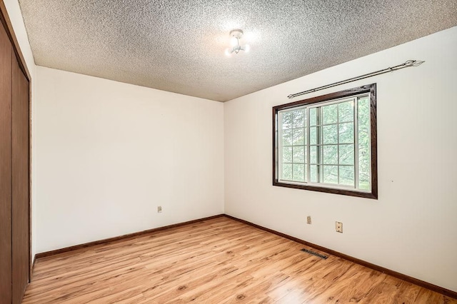 2108 Gunflint Trl, Brooklyn Park, MN 55444 - empty room with a textured ceiling and light wood finished floors