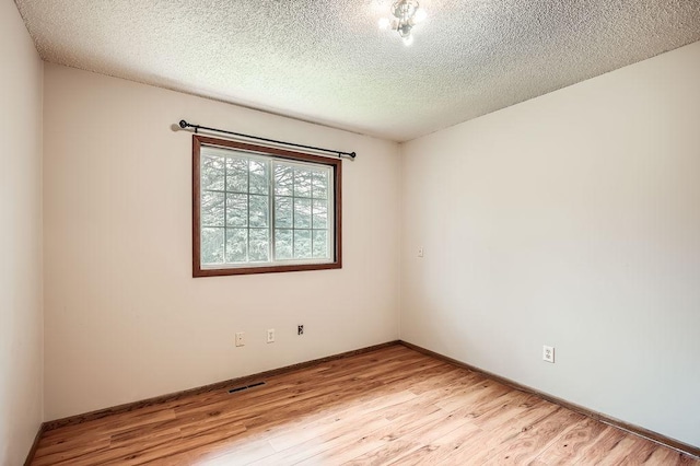 2108 Gunflint Trl, Brooklyn Park, MN 55444 - spare room featuring light wood-style floors and a textured ceiling