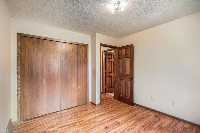 2108 Gunflint Trl, Brooklyn Park, MN 55444 - unfurnished bedroom with light wood-style floors, a closet, and a textured ceiling