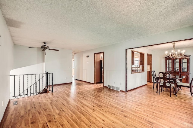 2108 Gunflint Trl, Brooklyn Park, MN 55444 - living room featuring a chandelier, light wood-style floors, a textured ceiling, and a ceiling fan