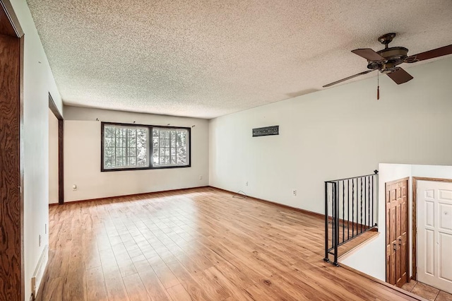 2108 Gunflint Trl, Brooklyn Park, MN 55444 - spare room featuring a textured ceiling, light wood-style flooring, and ceiling fan