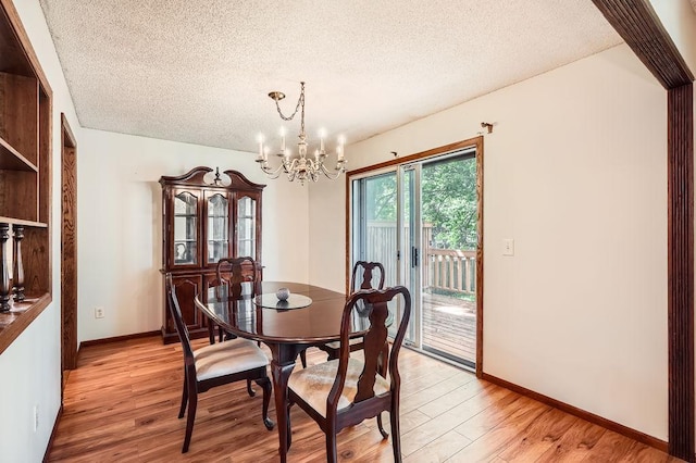 2108 Gunflint Trl, Brooklyn Park, MN 55444 - dining space featuring a textured ceiling, a chandelier, and light wood-style flooring