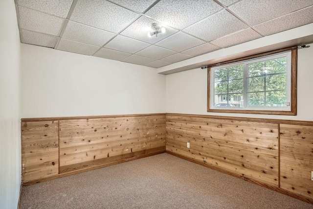 2108 Gunflint Trl, Brooklyn Park, MN 55444 - spare room featuring a drop ceiling, a wainscoted wall, carpet flooring, and wooden walls
