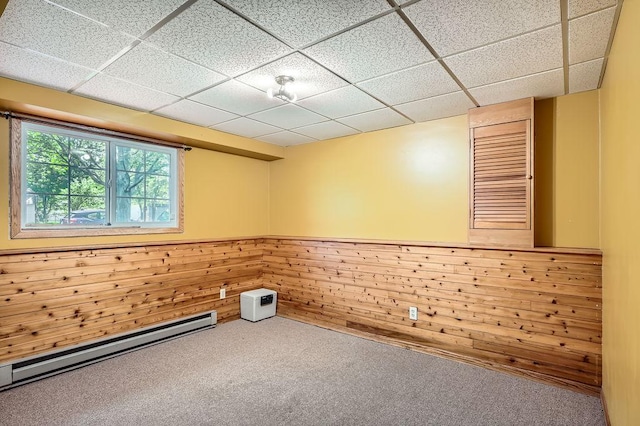 2108 Gunflint Trl, Brooklyn Park, MN 55444 - unfurnished room featuring baseboard heating, carpet, wood walls, a paneled ceiling, and a wainscoted wall