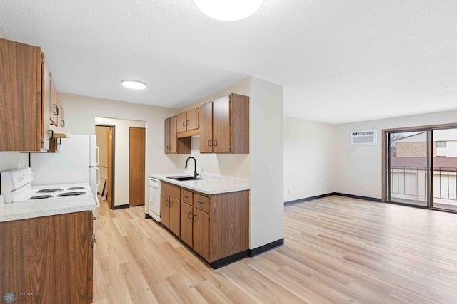 kitchen featuring white dishwasher, a sink, light wood-type flooring, light countertops, and a textured ceiling