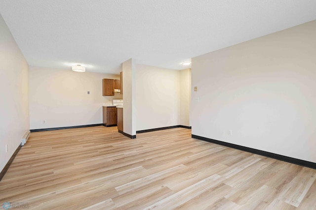 unfurnished living room featuring baseboards and light wood-style flooring