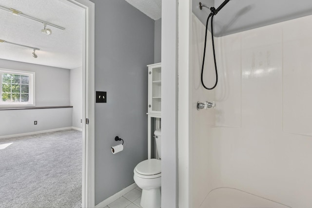 1604 Viking Dr, Buffalo, MN 55313 - bathroom with rail lighting, a shower, a textured ceiling, baseboards, and toilet