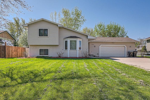 split level home featuring a front lawn, driveway, a garage, and fence