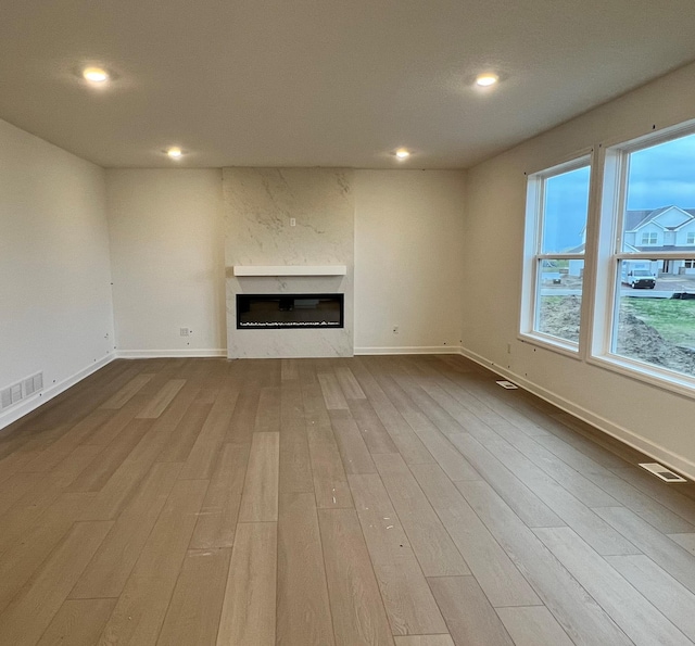 3112 Sugar Maple Dr, Chaska, MN 55318 - unfurnished living room with wood finished floors, a glass covered fireplace, recessed lighting, and baseboards