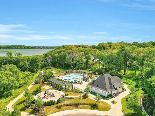 bird's eye view of a large body of water, a pool area, and a forest