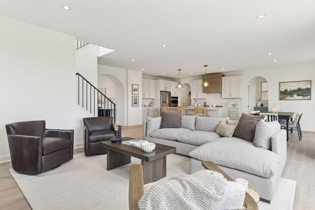 4612 Meadowview Ln, Minnetrista, MN 55331 - living area featuring arched walkways, light wood-style floors, recessed lighting, and stairs