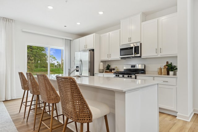 2146 Tyrone Dr, Shakopee, MN 55379 - kitchen with stainless steel appliances, recessed lighting, a sink, white cabinets, and a center island with sink