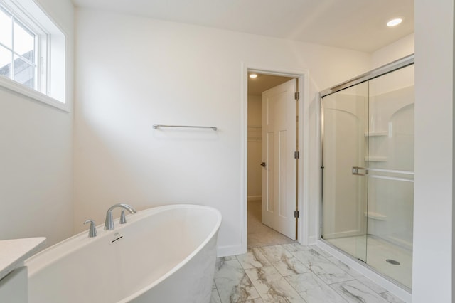 20092 67th Ave, Corcoran, MN 55340 - full bath featuring a stall shower, marble look tiles, a freestanding tub, a spacious closet, and recessed lighting