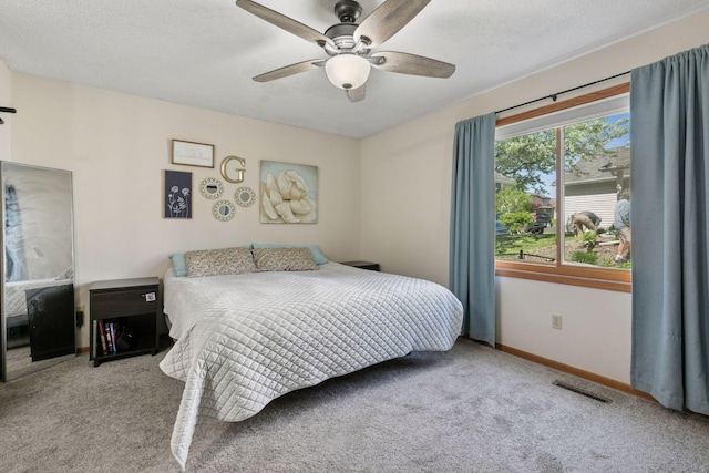 carpeted bedroom with baseboards, a ceiling fan, and a textured ceiling