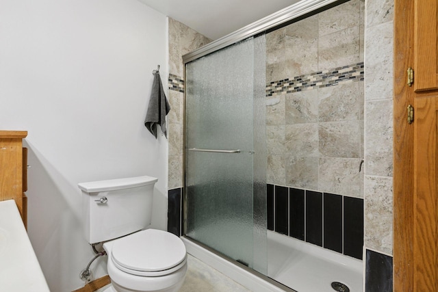 bathroom with a shower stall and toilet