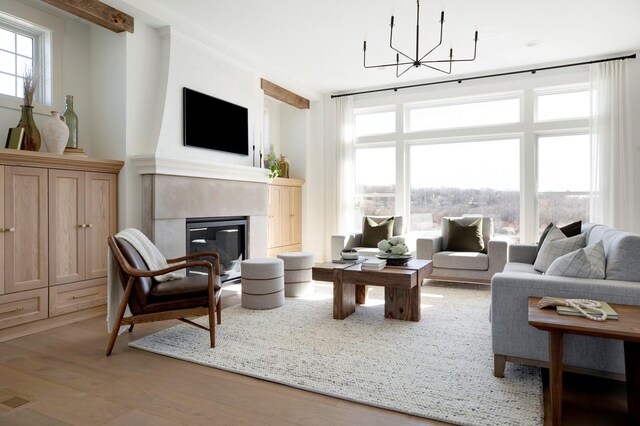 301 3rd St, Excelsior, MN 55331 - living room featuring a chandelier, a fireplace, light wood-type flooring, and healthy amount of natural light