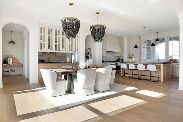301 3rd St, Excelsior, MN 55331 - dining space with a chandelier, arched walkways, light wood-style floors, and recessed lighting