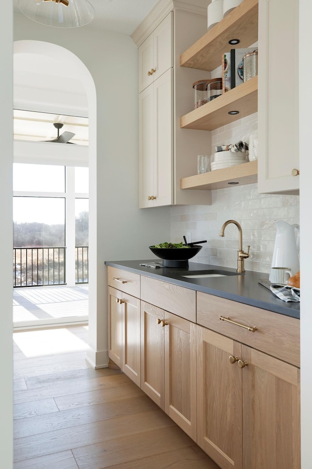 301 3rd St, Excelsior, MN 55331 - bar featuring tasteful backsplash, arched walkways, and light wood-style floors