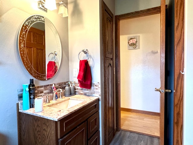 1112 10th St, Gaylord, MN 55334 - bathroom featuring wood finished floors, backsplash, vanity, and baseboards