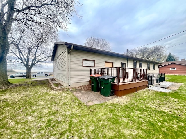 1112 10th St, Gaylord, MN 55334 - back of house featuring a deck and a lawn