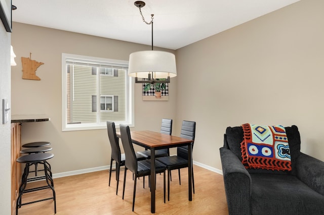 6477 Regency Ln, Eden Prairie, MN 55344 - dining space featuring light wood-type flooring, baseboards, and a chandelier