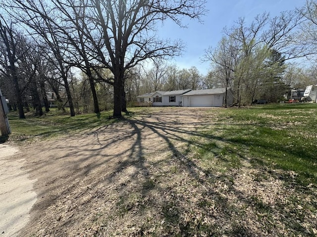view of green lawn featuring a garage