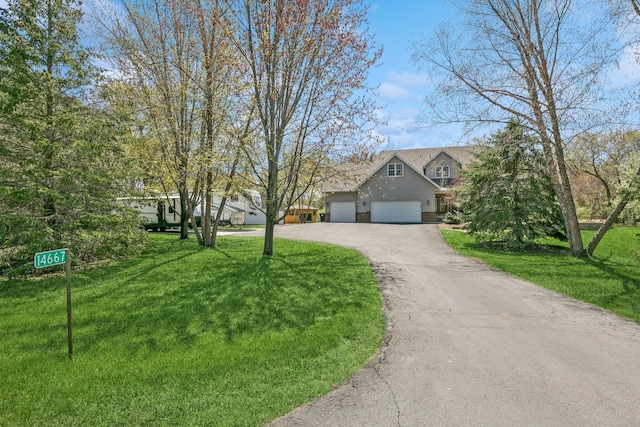 view of front of house with driveway, a front lawn, and an attached garage