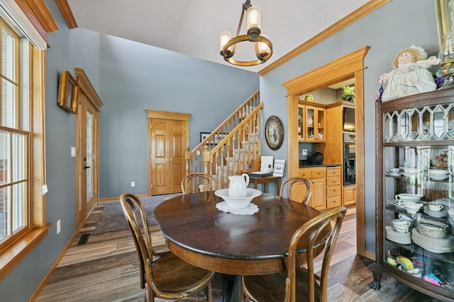 dining room with dark wood-type flooring, stairs, baseboards, and a chandelier