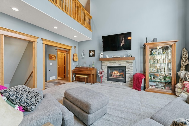 living area featuring a fireplace, recessed lighting, and a high ceiling