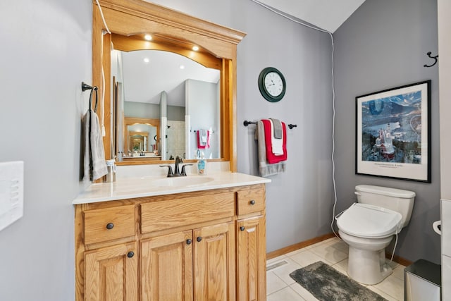 bathroom featuring tile patterned flooring, vanity, toilet, and baseboards