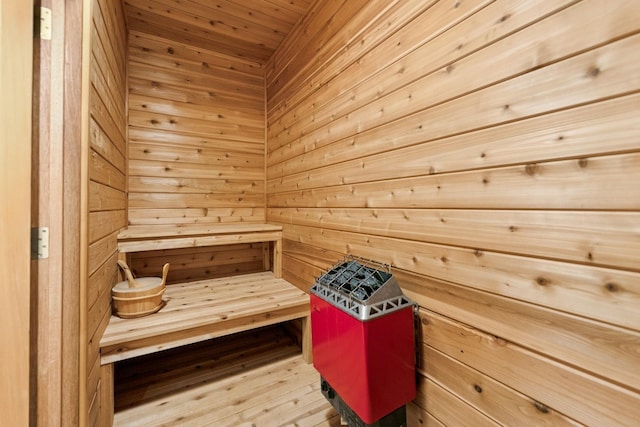relaxing sauna featuring wooden walls and wood ceiling