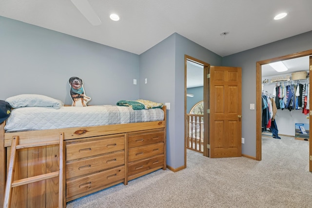 bedroom featuring baseboards, light carpet, a spacious closet, a closet, and recessed lighting