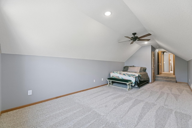 bedroom with lofted ceiling, baseboards, carpet flooring, ceiling fan, and a textured ceiling