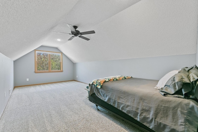carpeted bedroom featuring baseboards, lofted ceiling, a textured ceiling, and a ceiling fan