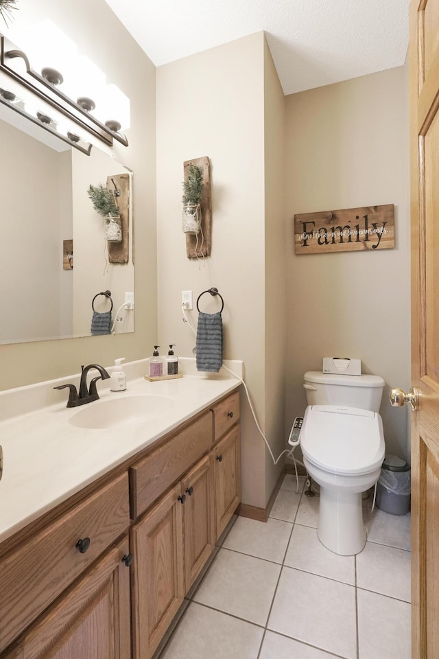 bathroom featuring toilet, tile patterned floors, and vanity
