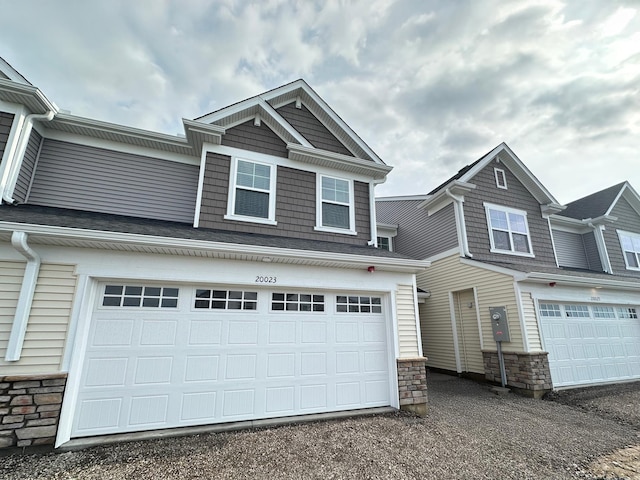 20023 62nd Pl, Corcoran, MN 55340 - view of front of property with stone siding, an attached garage, and driveway