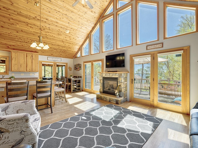 1351 Lone Pine Ln, Garfield Twp, WI 54001 - living area with high vaulted ceiling, light wood-style flooring, a stone fireplace, a chandelier, and french doors